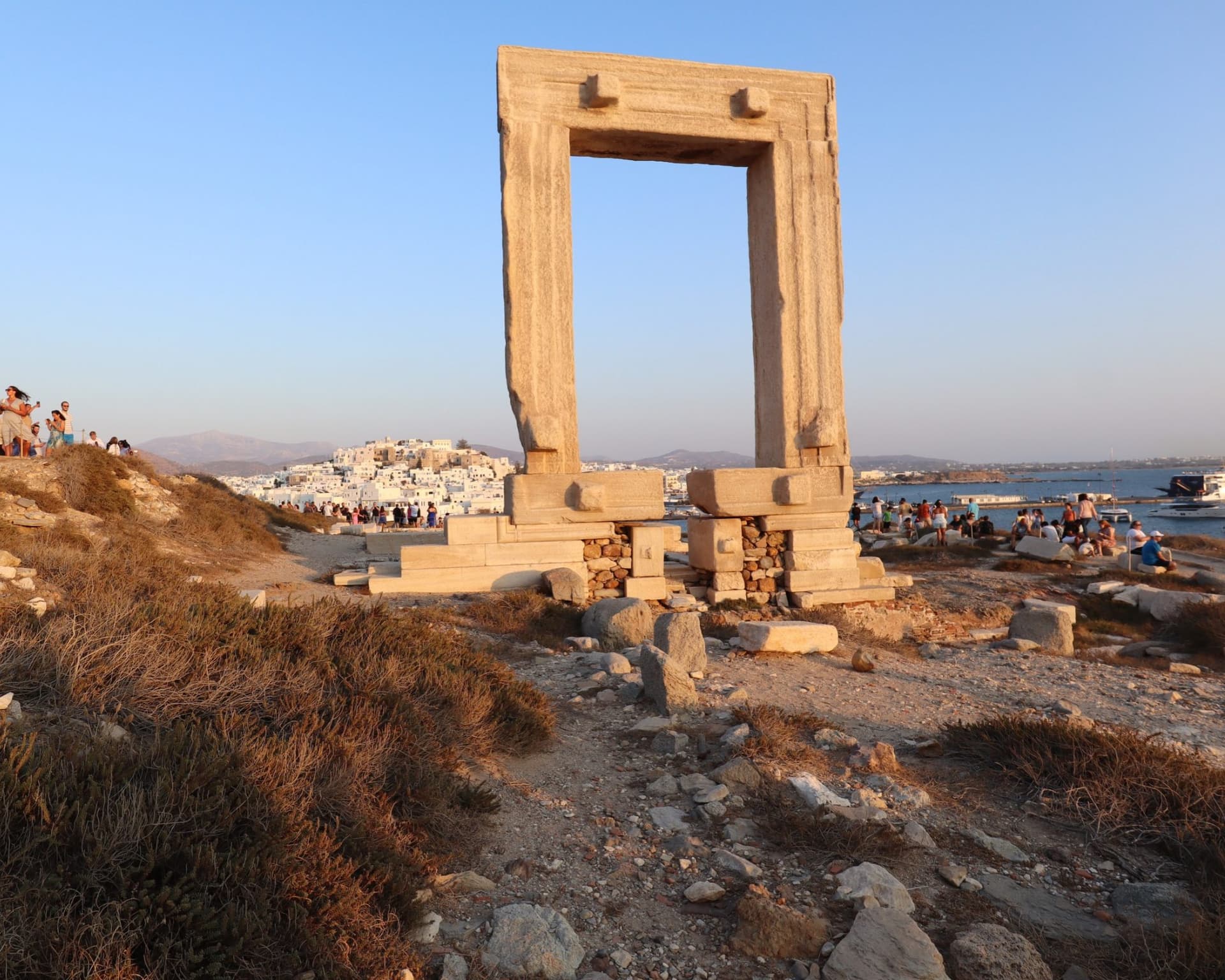 The Portara on Palatia islet at sunset, with Naxos Chora and the harbour behind it