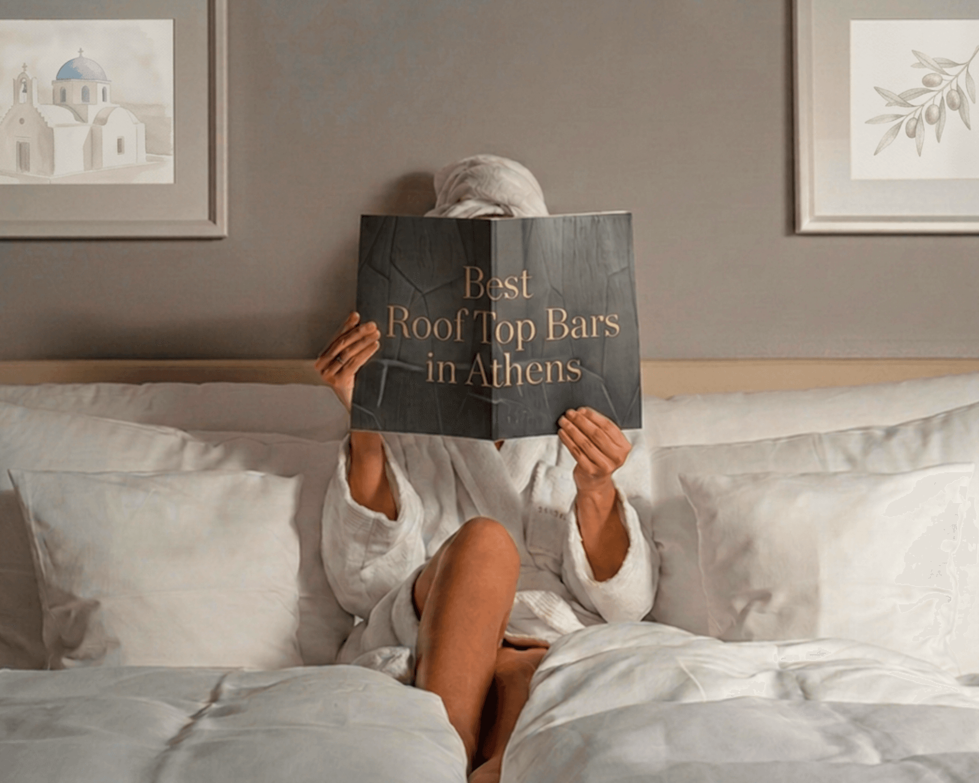 A guest in a robe reading in bed in a Greek hotel room — Monobrow Hotels
