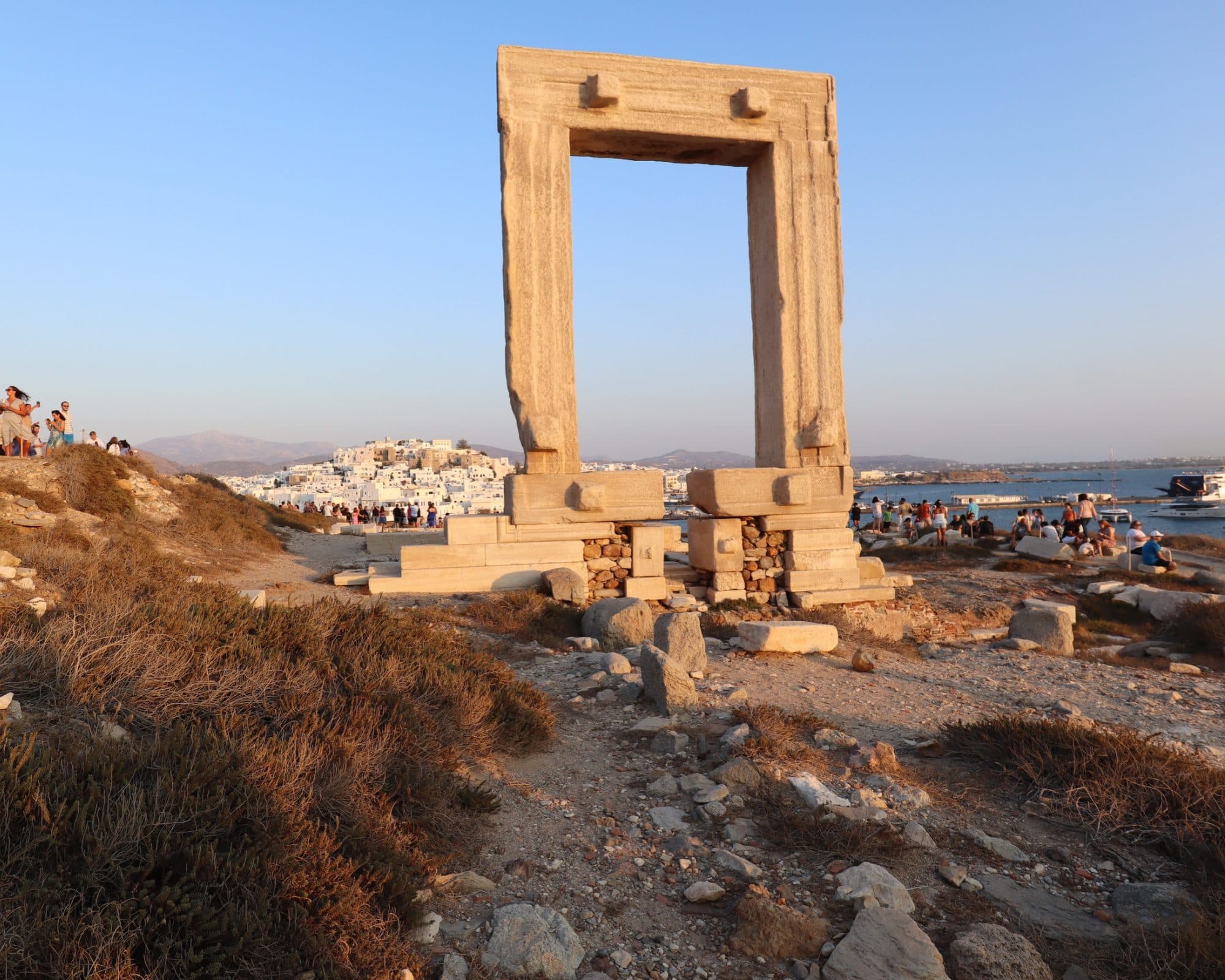 The Portara on Palatia islet at sunset, with Naxos Chora and the harbour behind it