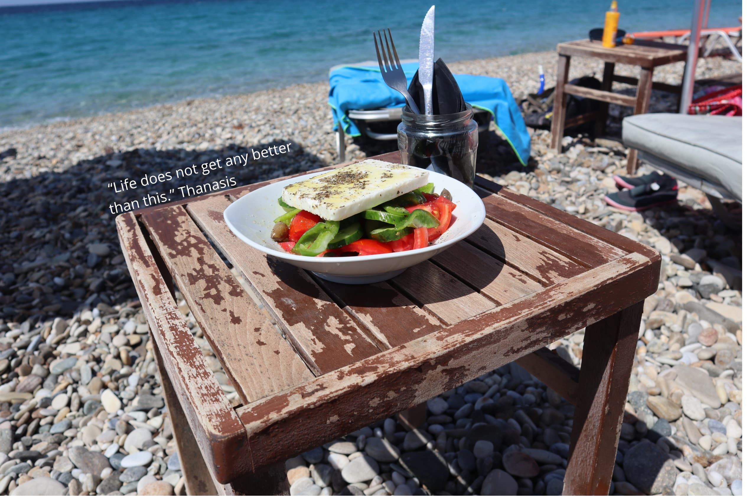 A Greek salad on a beach taverna table by the sea — Monobrow Day Tours